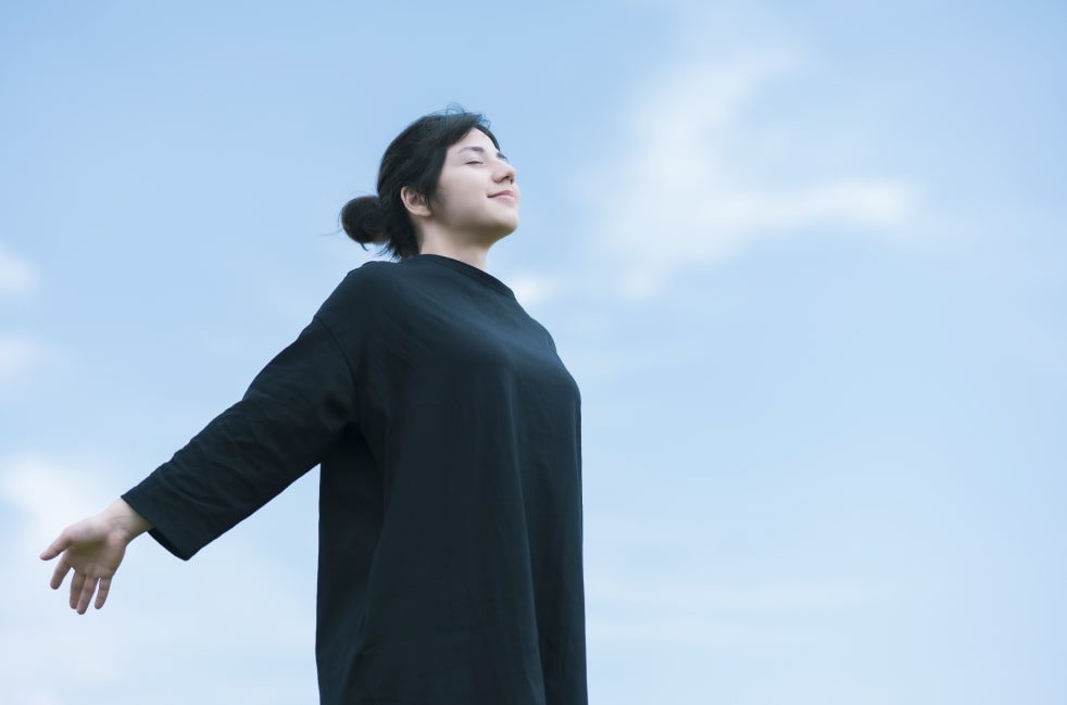 晴れた日に深呼吸する女性